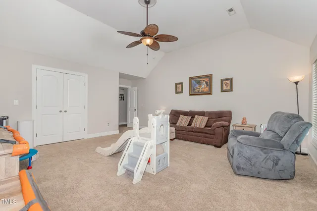 a living room with furniture and a ceiling fan