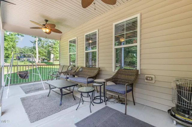a roof deck with table and chairs and potted plants