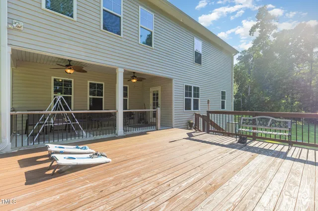 a swimming pool with wooden deck and furniture