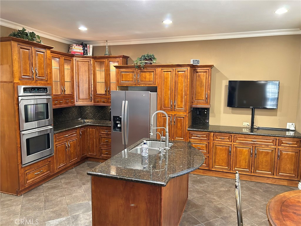 300 South Timken Road Anaheim, CA 92808 - Photo 14 of 40 a kitchen with stainless steel appliances granite countertop a refrigerator a stove and a sink with wooden cabinets