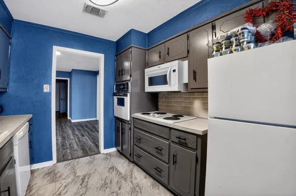 a kitchen with stainless steel appliances granite countertop a refrigerator a stove and a sink with wooden floor