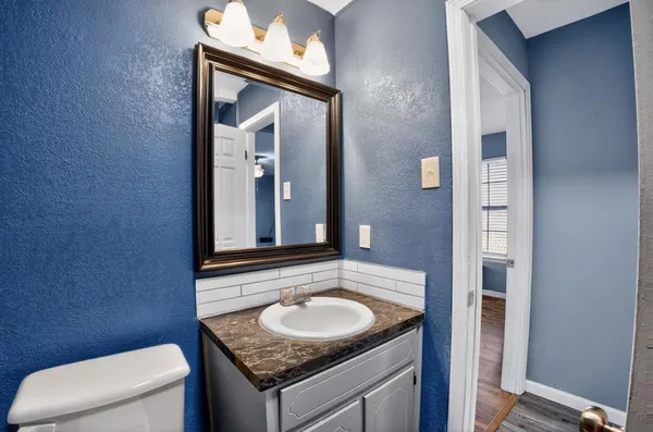 a bathroom with a granite countertop sink and a mirror