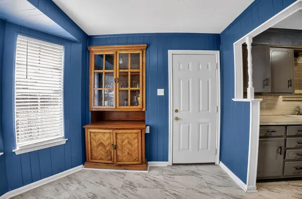 an empty room with windows cabinet and mirror
