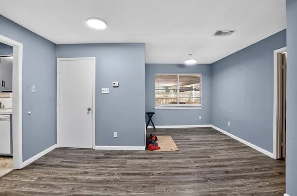 a view of empty room with wooden floor