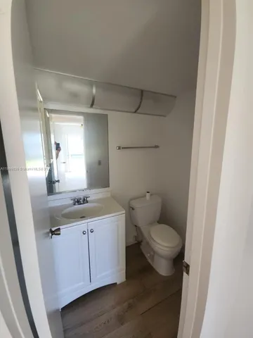 a bathroom with a granite countertop toilet sink and mirror