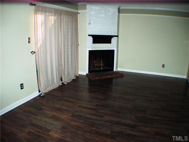 165 Newton Road Raleigh, NC 27615 - Photo 4 of 10 a view of a livingroom with wooden floor and a fireplace