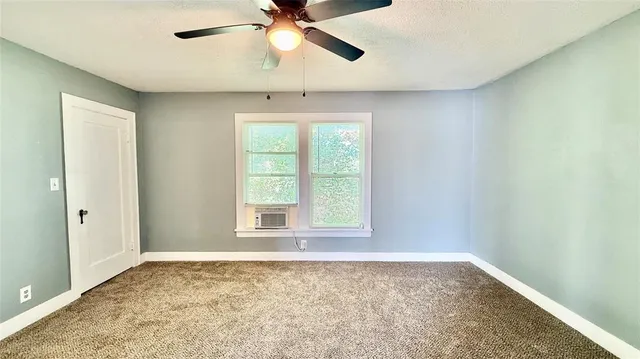 an empty room with a window and a fan