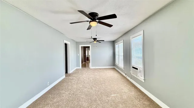 a view of a livingroom with a ceiling fan and window
