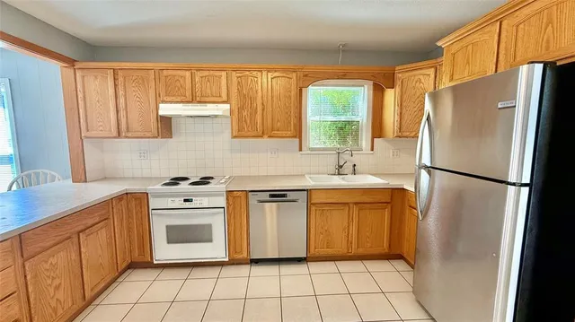 a kitchen with stainless steel appliances a refrigerator sink and stove