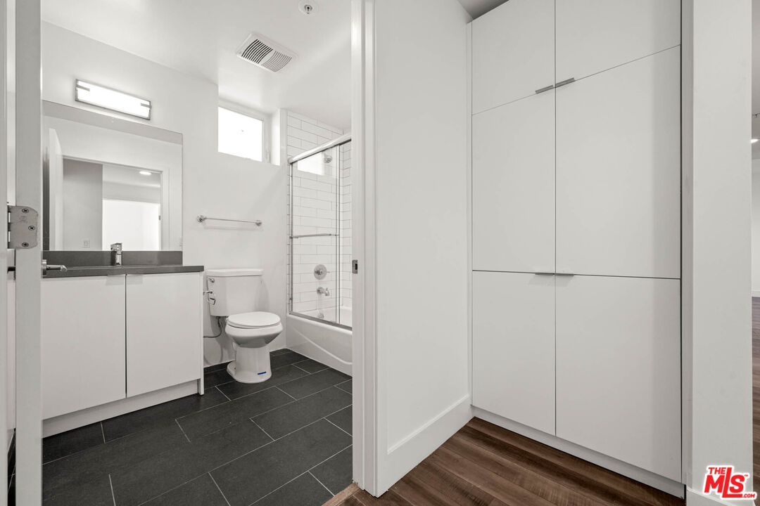 1215 South Bedford Street, Unit 105 Los Angeles, CA 90035 - Photo 11 of 27 a bathroom with a toilet sink and a mirror