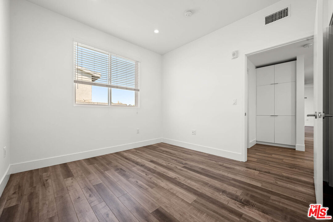 1215 South Bedford Street, Unit 105 Los Angeles, CA 90035 - Photo 15 of 27 an empty room with wooden floor and windows