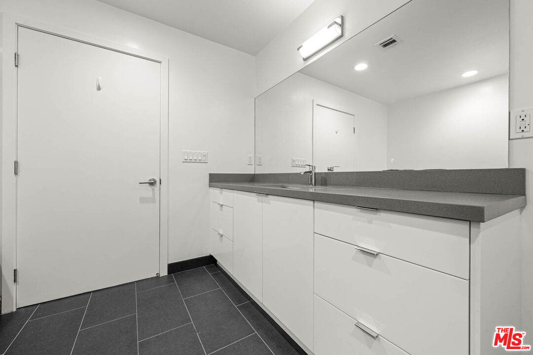 1215 South Bedford Street, Unit 105 Los Angeles, CA 90035 - Photo 21 of 27 a utility room with cabinets washer and dryer