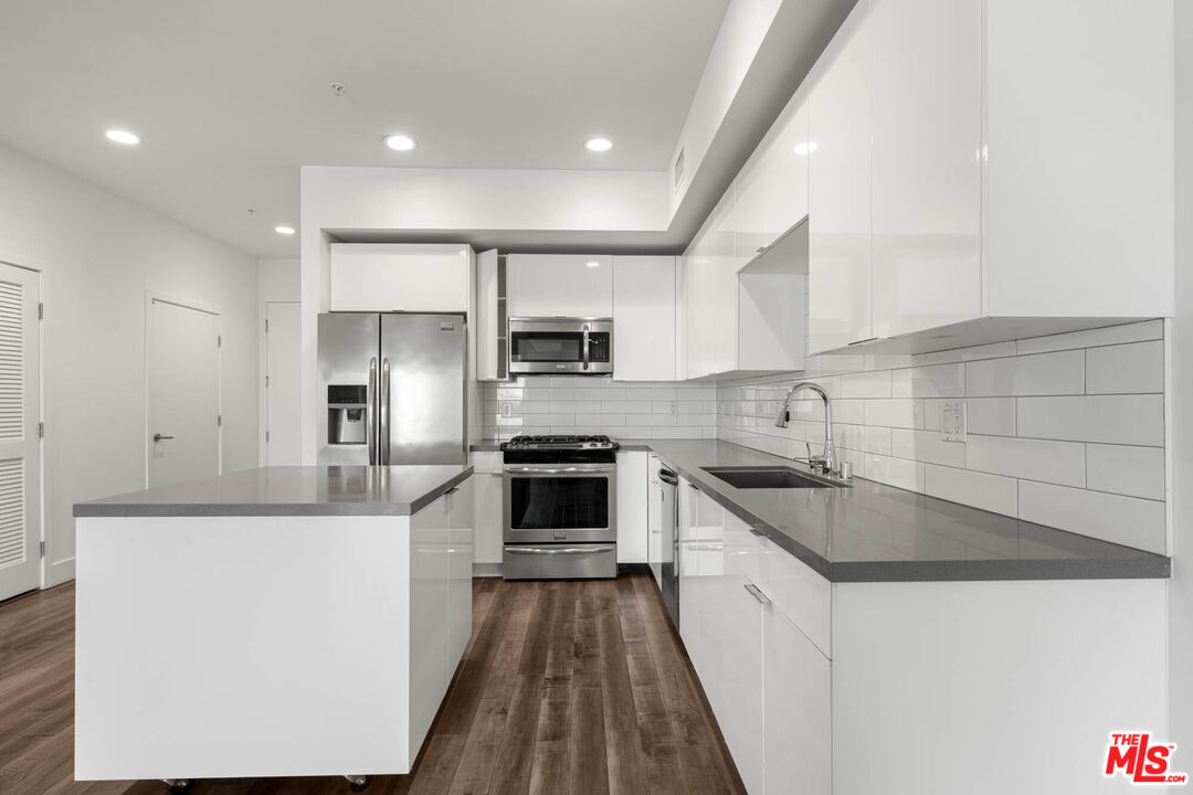 1215 South Bedford Street, Unit 105 Los Angeles, CA 90035 - Photo 3 of 27 a kitchen with stainless steel appliances a sink stove and refrigerator