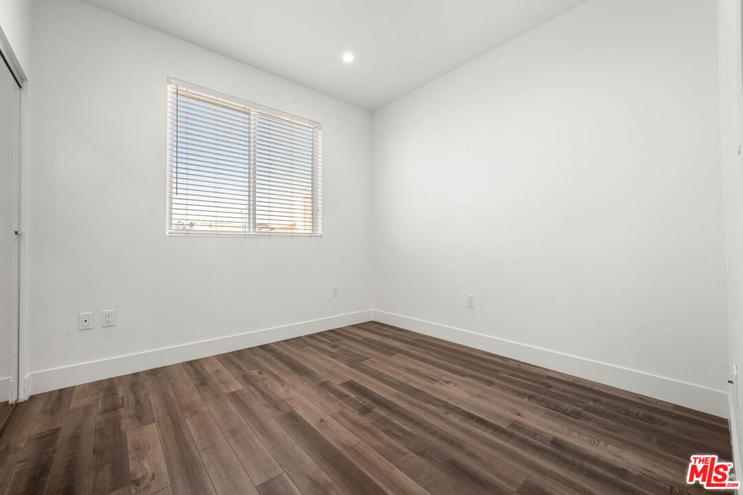 1215 South Bedford Street, Unit 105 Los Angeles, CA 90035 - Photo 9 of 27 an empty room with wooden floor and windows