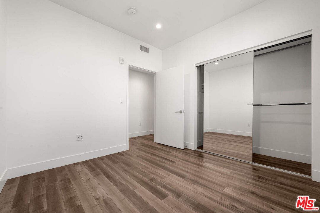 1215 South Bedford Street, Unit 105 Los Angeles, CA 90035 - Photo 10 of 27 a view of an empty room with wooden floor