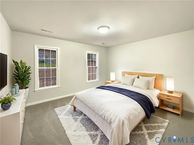 a bedroom with a large bed and a potted plant