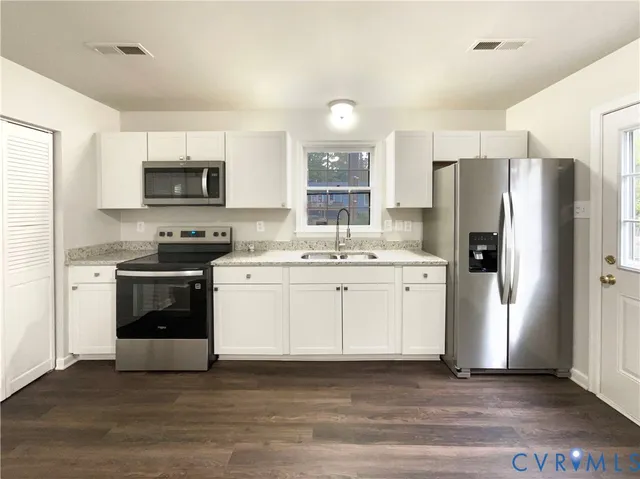 a kitchen with a refrigerator stove and white cabinets