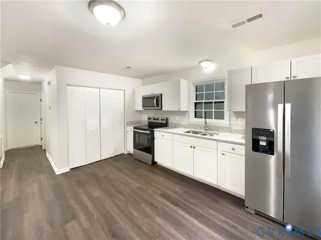 a kitchen with stainless steel appliances a refrigerator sink and microwave