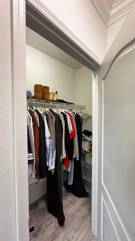 a view of walk in closet with clothes and shoes