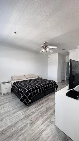 a bedroom with a bed window and a chandelier