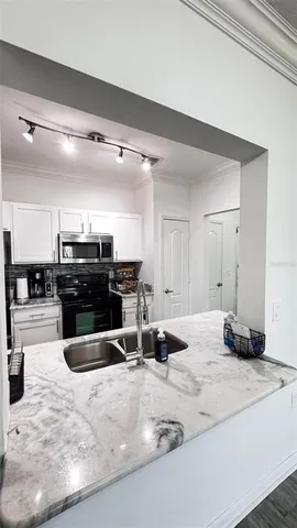 a kitchen with stainless steel appliances kitchen island granite countertop a stove and a sink