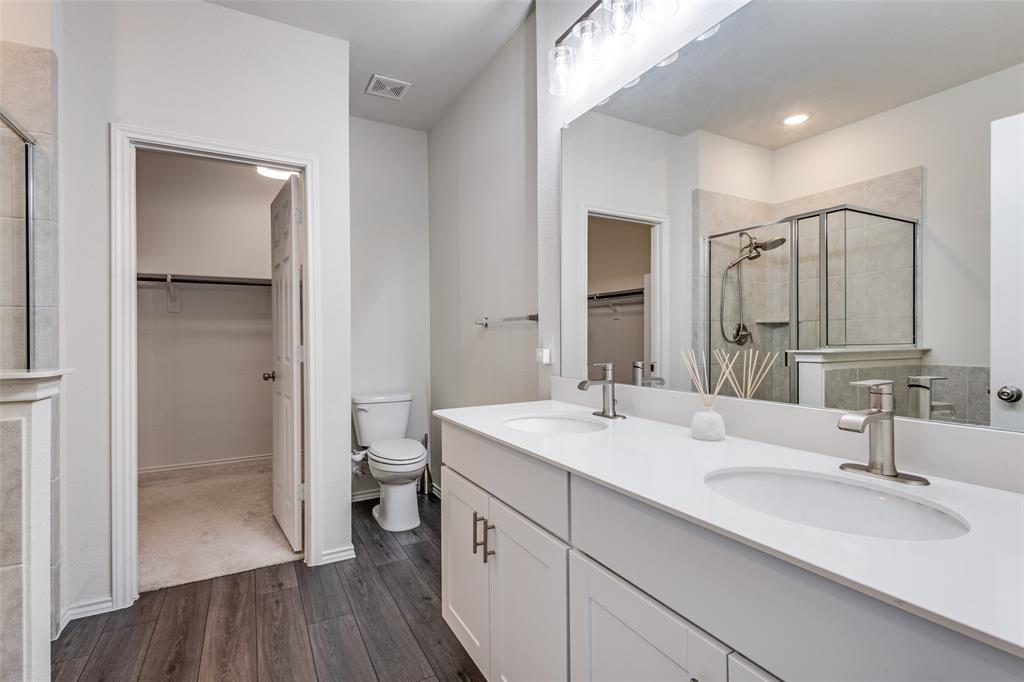 1810 Hummingbird Street Princeton, TX 75407 - Photo 17 of 25 a bathroom with a double vanity sink toilet and shower