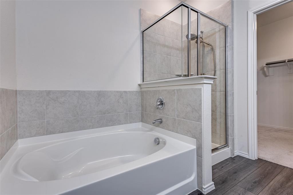 1810 Hummingbird Street Princeton, TX 75407 - Photo 18 of 25 a white bath tub sitting in a bathroom and shower