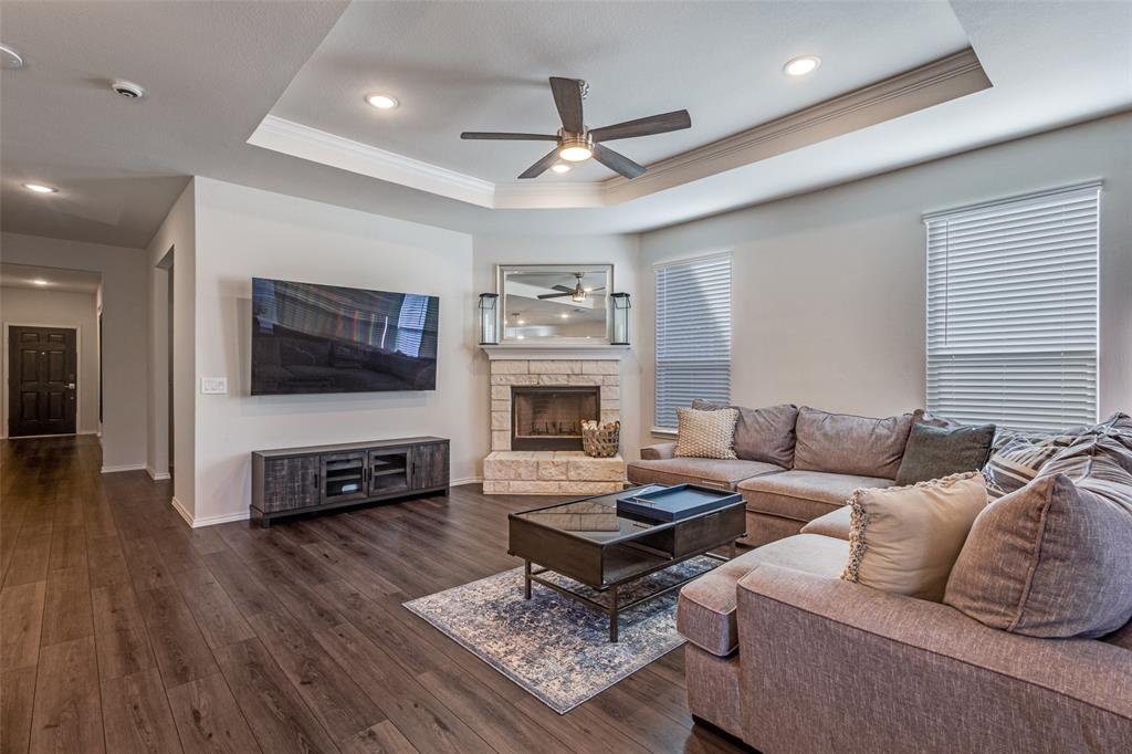 1810 Hummingbird Street Princeton, TX 75407 - Photo 4 of 25 a living room with furniture a flat screen tv and a fireplace