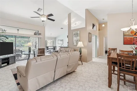 a living room with furniture a flat screen tv and a chandelier