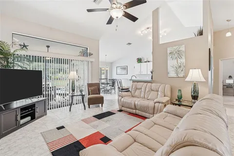 a living room with furniture a flat screen tv and a table