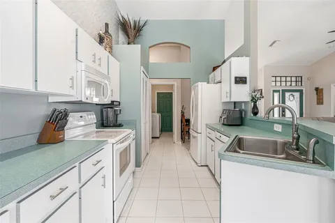 a kitchen with white cabinets and white appliances