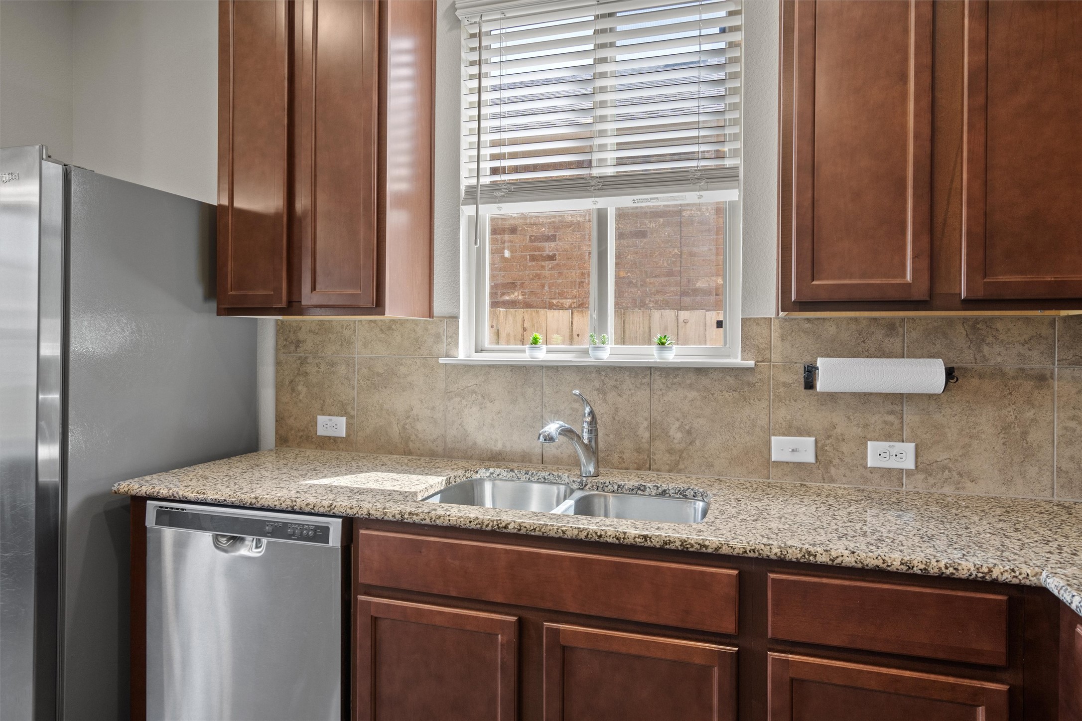 11816 Jackson Fls Way Manor, TX 78653 - Photo 14 of 40 a kitchen with granite countertop stainless steel appliances window sink and cabinets