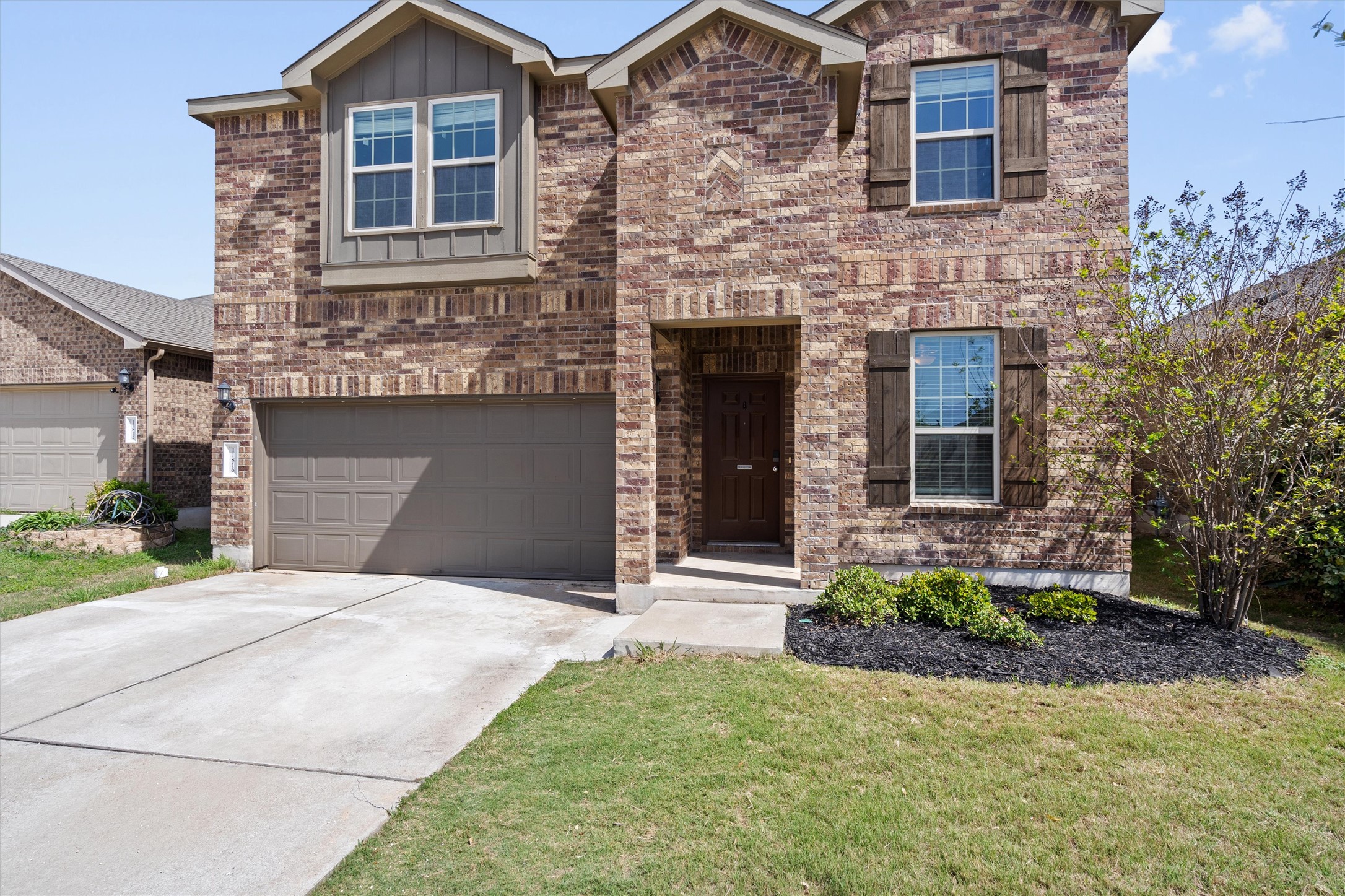 11816 Jackson Fls Way Manor, TX 78653 - Photo 3 of 40 a front view of a house with a garden