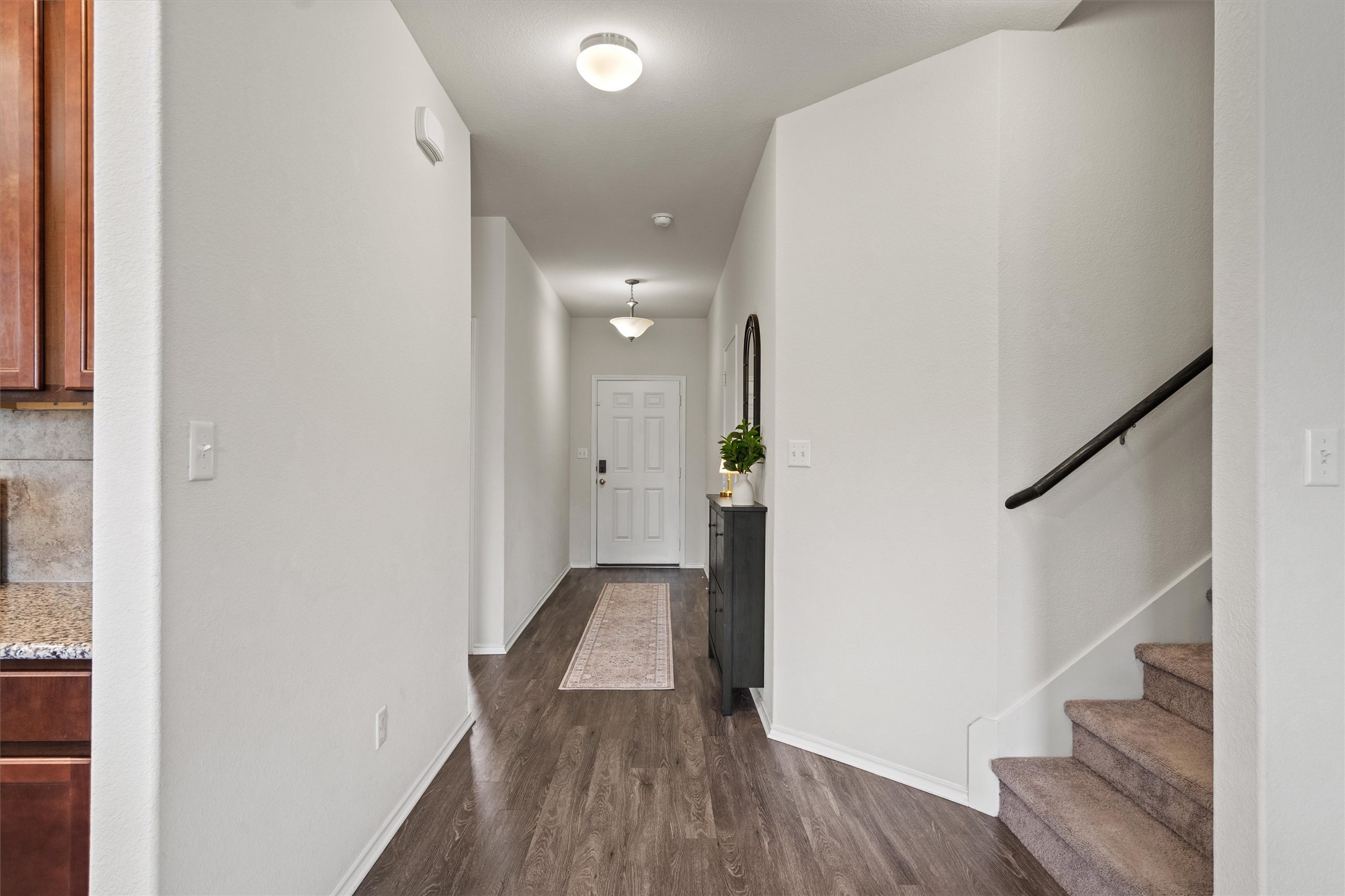 11816 Jackson Fls Way Manor, TX 78653 - Photo 4 of 40 a view of a hallway with wooden floor and staircase