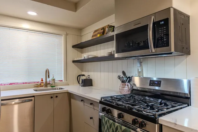 a kitchen with stainless steel appliances granite countertop a stove and a microwave