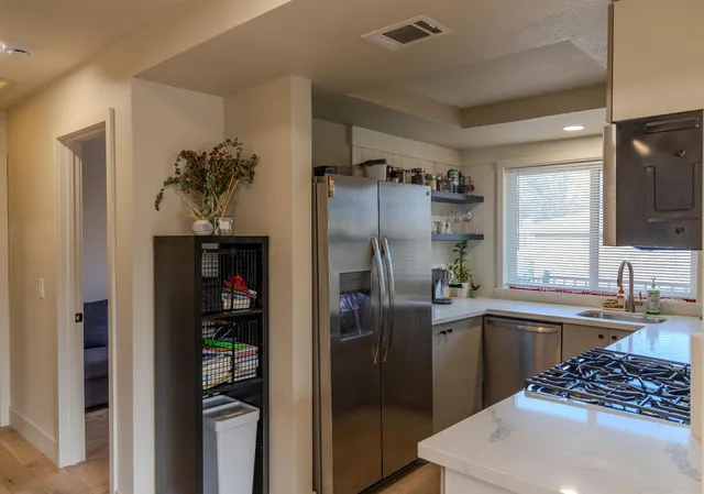 a kitchen with stainless steel appliances granite countertop a refrigerator and a sink