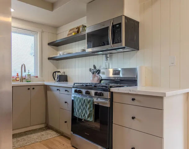 a kitchen with stainless steel appliances granite countertop a stove and a microwave