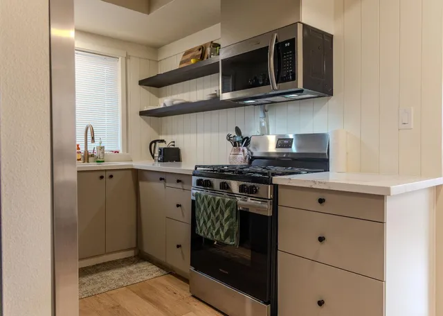 a kitchen with stainless steel appliances granite countertop a stove and a microwave