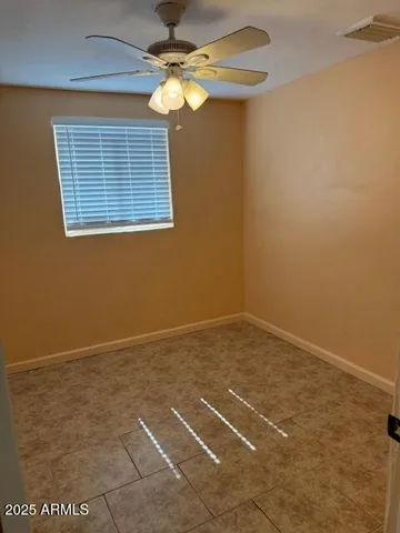 a view of a room with a ceiling fan and a window