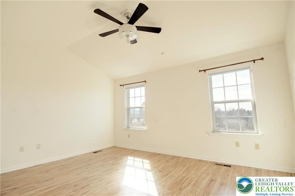5392 Spring Ridge Drive West Lower Macungie Township, PA 18062 - Photo 11 of 17 an empty room with wooden floor fan and windows