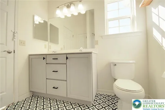 a bathroom with a sink a toilet and a window