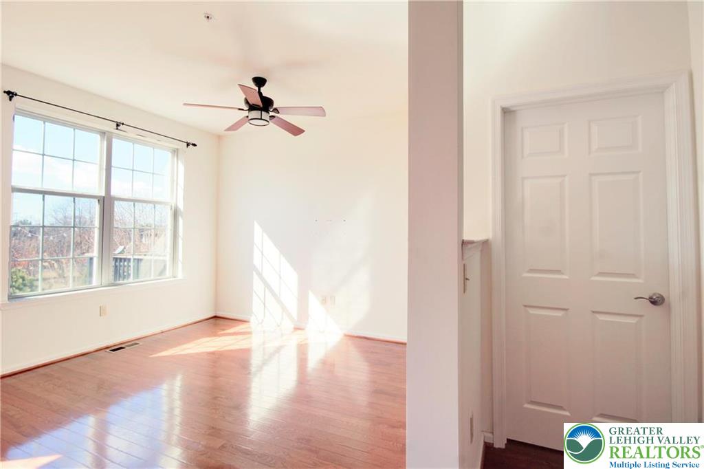 5392 Spring Ridge Drive West Lower Macungie Township, PA 18062 - Photo 6 of 17 an empty room with wooden floor fan and windows