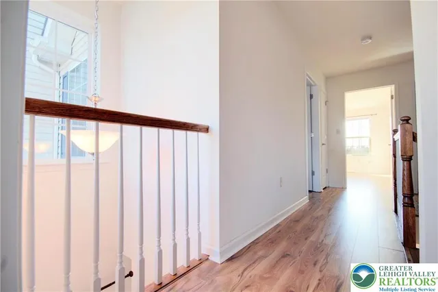 a view of a hallway with wooden floor and staircase