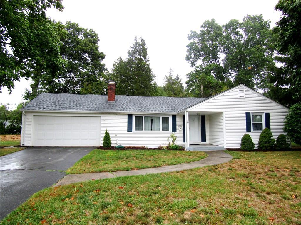 a front view of house with yard and trees around