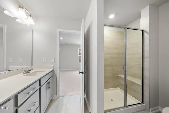 a bathroom with a shower sink and mirror