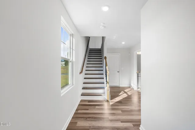 a view of entryway and hall with wooden floor