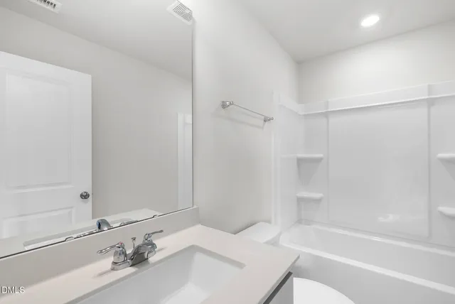 a bathroom with a bathtub sink vanity and a shower