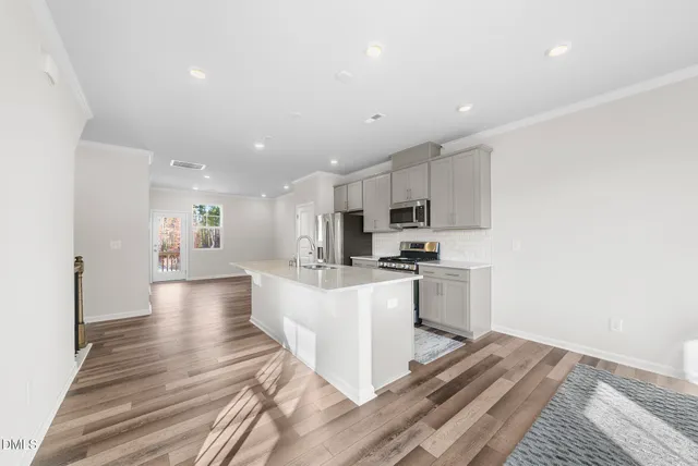 a kitchen with stainless steel appliances granite countertop a sink stove and refrigerator