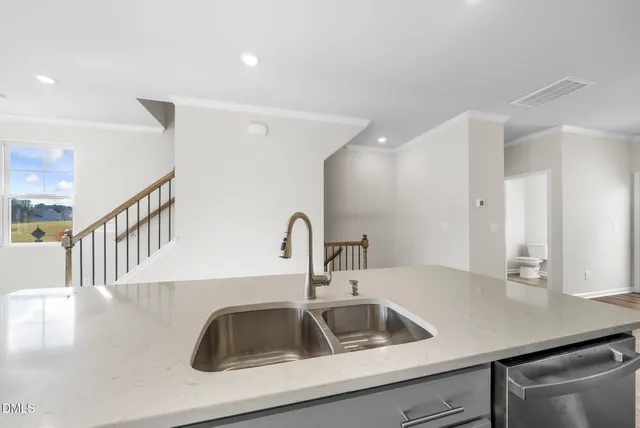 a kitchen with stainless steel appliances granite countertop white cabinets stove top oven and sink