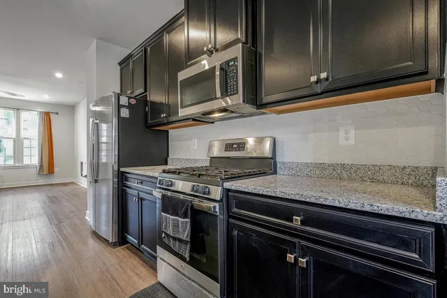 a kitchen with granite countertop stainless steel appliances and wooden cabinets